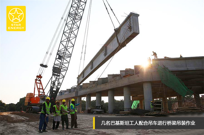 幾名巴基斯坦工人配合吊車(chē)進(jìn)行橋梁吊裝作業(yè)